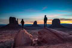 Hikers taking in views of Monument Valley Navajo Tribal Park on the Utah-Arizona border