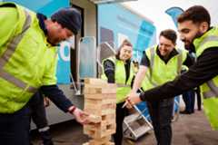 Colleagues having fun time together while playing tumbling tower