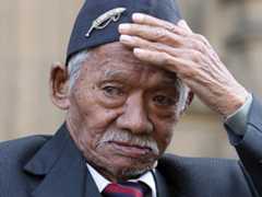 Photo of Honorary Sergeant Lachiman Gurung outside the Houses of Parliament in London.
