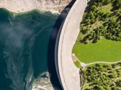 body of water next to a wall with greenery on the other side