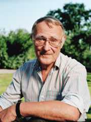 イケアの創業者イングヴァル・カンプラードの肖像写真。ピンク、白、グリーンのストライプのシャツを着て、屋外で微笑んでいる。