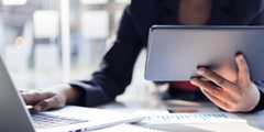 Using a tablet computer and laptop for daily work tasks.