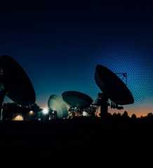 multiple satellite dishes in a night sky