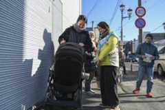 Hikaru Fujita (second from left) greets people in the city of Azumino, Nagano Prefecture, on Feb. 3.
