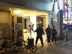 Police inspect the scene where three 17-year-old boys were stabbed on Saturday night.