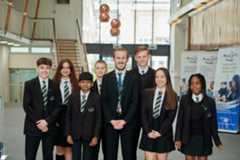 A group of children stood with the principal, smiling for a photo