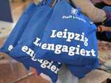 Engagementmesse 2023 drei blaue Stoffbeutel mit Schriftzug "Leipzig engagiert" werden über eine Schulter hängend getragen