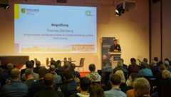 Bürgermeister Thomas Dienberg steht am Rednerpult auf der Bühne und spricht zum Publikum