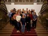 Die Beiratsmitglieder stehen auf der großen Treppe in der unteren Wandelhalle des Neuen Rathauses.