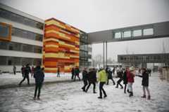 Schüler spielen auf dem Schulhof des neugebauten Reclam-Gymnasiums im Schnee.