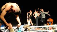 Halbnackte Menschen performen zwischen Müllhaufen auf der Bühne