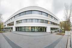 Dreistöckiges weißes Neubau-Gebäude mit durchgängigen Fensterfronten