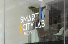 Smart City Lab Blick von außen durch ein Fenster mit der Aufschrift Smart City Lab Leipzig