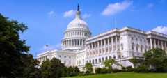 Exterior view of the U.S. Capitol with blue sky and green lawn