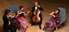 Image of a string quartet, pictured from above, playing their instruments