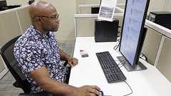 Cowboy wrangling bull with white horse running alongside.