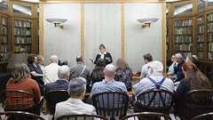 Inventor Charles S.L. Baker and another man, possibly Baker's brother Peter, standing behind heating (radiator) system. One man is holding a knob that is attached to two wires.