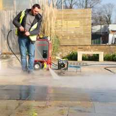 Man showing how to clean porcelain outdoor tiles with a jet wash held at the right angle and with correct power setting