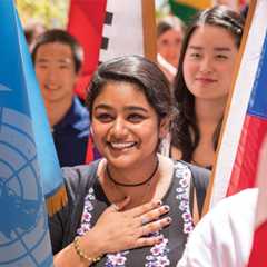 Students carrying various national flags at a Commencement ceremony.