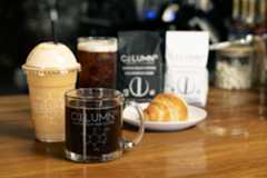 Three coffee drinks and a croissant on a table