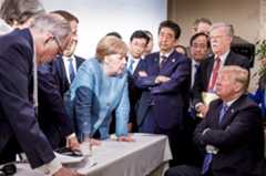 In this photo made available by the German Federal Government, German Chancellor Angela Merkel, center, speaks June 9, 2018, with President Donald Trump, seated at right, during the G7 Leaders Summit in La Malbaie, Quebec, Canada. (Jesco Denzel/German Federal Government via AP)