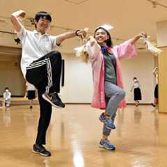 紙谷さんから動きを教わる記者（左）。動きを習得するごとに表情が緩んでいった