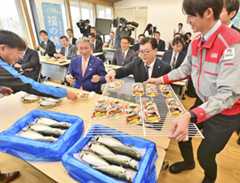 出発式で脂の乗った「福の鯖」のにぎりを試食する関係者ら＝４月１０日、浪江町