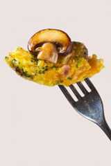 A bite of mushroom egg bites featuring crimini mushrooms on the tip of a fork