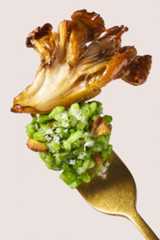 A bite of Maitake mushroom risotto on the tip of a fork