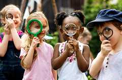 children looking through magnifying glasses