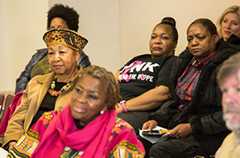 close up of women at community forum with John Schelp's profile in lower right corner