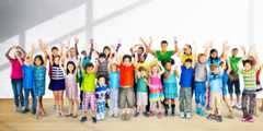 Group of diverse children with arms raised 
