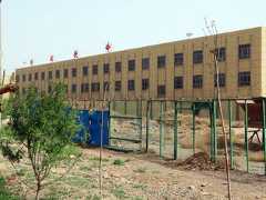 オーストラリア戦略政策研究所が「強制収容所」と指摘した施設。門には中国共産党の教育施設である「党校」などと書かれていた。監視塔があり、すべての窓が鉄格子付きだった＝4月27日、カシュガル市