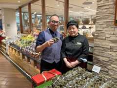 杉野隆店長（左）とスタッフ。あいさつや所作を徹底する日本流の接客指導が定着し、ＢＨＧマーケットプレイスの信頼感ある売り場づくりにつながっている＝10月、北京市