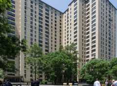 Tall 1,105-unit building complex with trees in front.