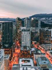The city of Vancouver shown as dusk with lights and traffic movement.