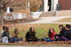 Students gathered in a quad talking in the fall