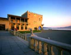 Fachada del Parador de Baiona iluminada al amanecer desde la entrada