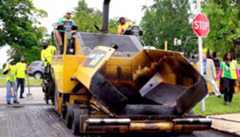 Workers operating a paving machine