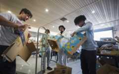 A Thanksgiving helping hand. From left: Noah Gentry, T.J. Veal, Jadyn Bazemore and Marco Phillips, all seniors and members of the Landstown High School track team, break down boxes after they were unpacked Monday afternoon, Nov. 24, 2025, at the First Baptist Church Community Outreach Center in Norfolk. The track team was there doing a community service activity with their coach Thomas Anderson who teaches Health of PE at Landstown High School. (Bill Tiernan/for The Virginian-Pilot)