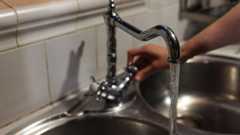 Una persona obre una aixeta de la cuina