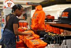 An student looking at R I T branded apparel at the campus store.