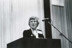 Loretta Ford, former School of Nursing dean, stands at a podium in a suit and tie, exuding professionalism and authority.