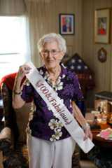 Celebrating her 100th birthday, Loretta Ford, former dean of the School of Nursing, holds a sash with the milestone inscription.