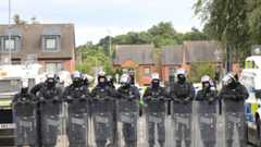 Police officers in riot gear on the Lower Ormeau Road in Belfast on Saturday