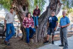SUT-L-LINCOLN-ACRES_0008 Doyle Morrison (left), Alisha Morrison, (second to left), Ashley Morrison (center), Jose Vasquez (second to right), and Kurt Worden, President, Lower Sweetwater Fire Protection District (right) in front of the old pepper tree at Lincoln Acres County Park in National City on Oct. 28, 2025. (Ariana Drehsler / For The San Diego Union-Tribune)