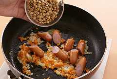 フライパンにサラダ油を中火で熱し、玉ねぎ、にんじんを入れてしんなりするまで炒める。ソーセージを加えて炒め、レンズ豆、ローリエを加えてサッと炒める