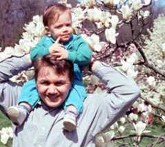 color photo of a man with a baby on his shoulders