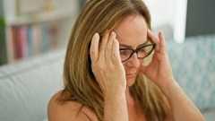 Woman holding her head in distress, experiencing headache or mental stress.