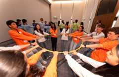 2025 JIC finalists lean backward while holding a circular rope as part of team-building activities